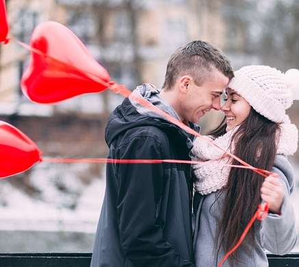 couple with woman holding heart shaped balloons