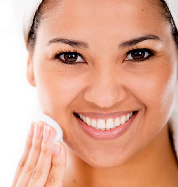 woman cleaning her face with cotton circle