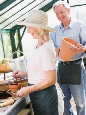 couple planting seeds in greenhouse