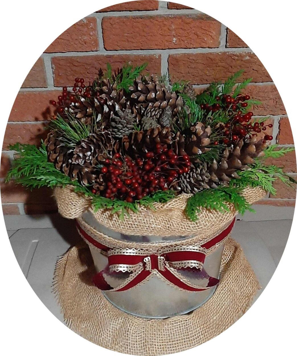 galvanized bucket, top view, filled iwth evergreens and pine cones